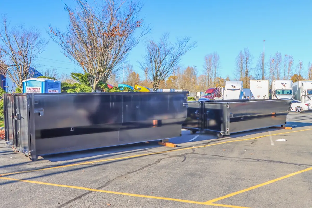 Professional dumpster rental service with roll-off container on residential driveway in Adelphi